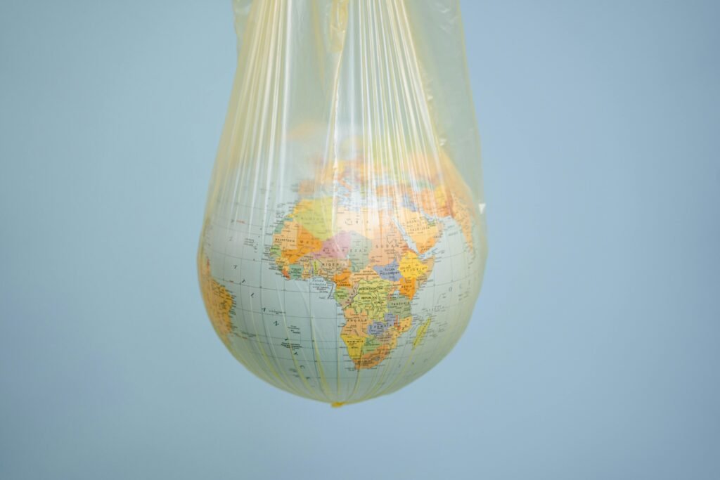 A globe wrapped in plastic highlighting global environmental issues.